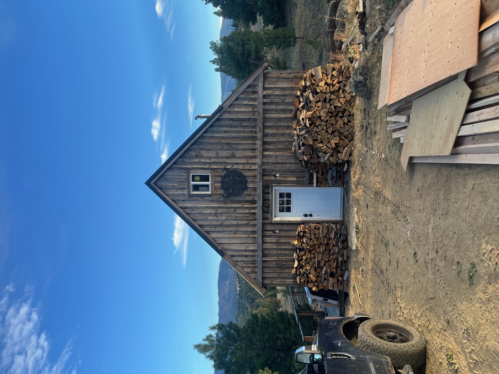 Rustic cabin with stacked firewood on the FSG Montana ranch property